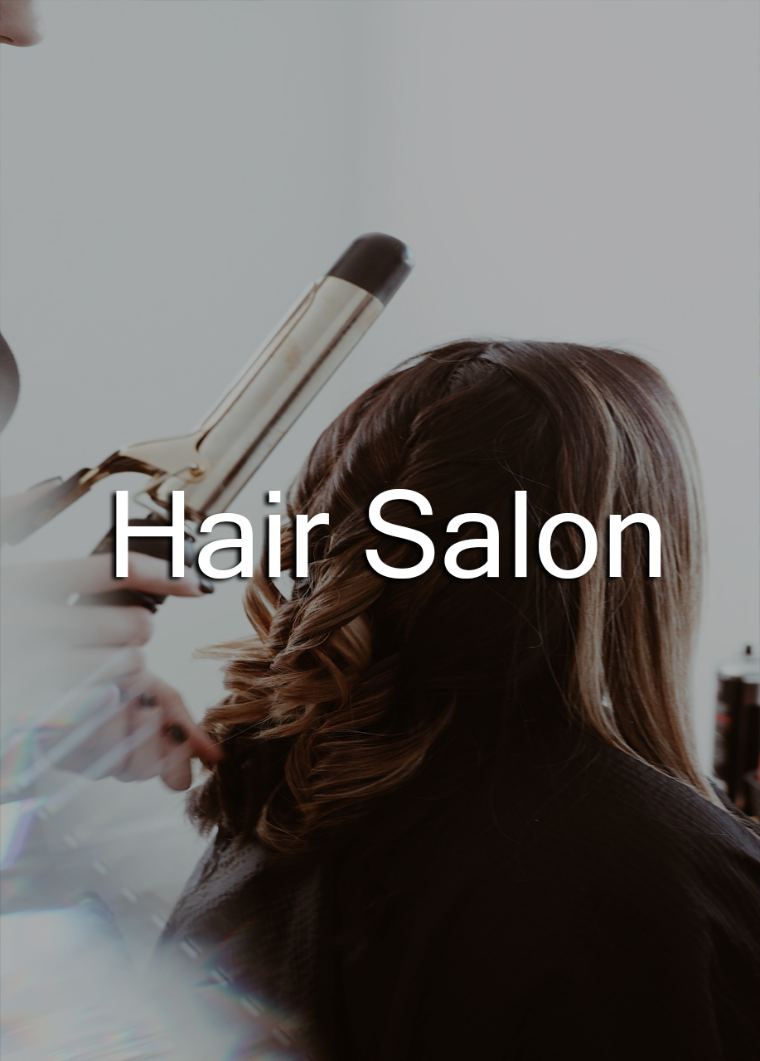 A stylist curling a client's hair